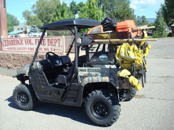 black metal rack on the back of an UTV filled with stuff