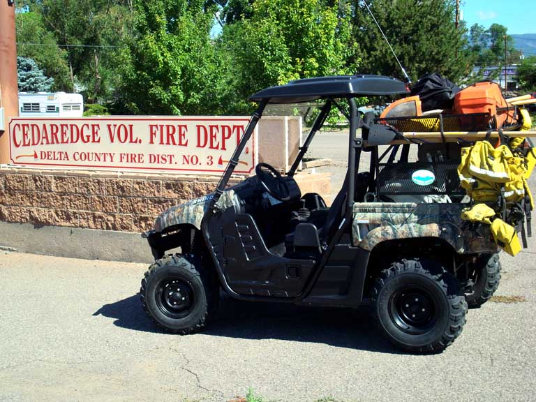 black metal rack on the back of an UTV filled with bags and other materials